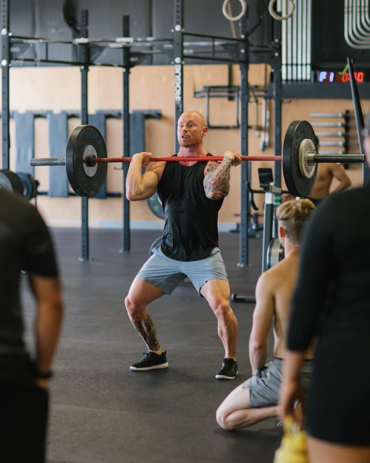 Ryan Hignell coaching a barbell lift during a group functional fitness class in Salt Lake City